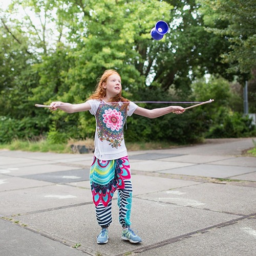 bs-toys-diabolo-motoriek-speelgoed.jpg Kind speelt met BS Toys Diabolo Blauw in de tuin