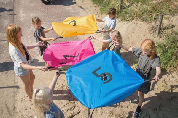 Kinderen spelen actief buitenspel met eekhoorn parachutes