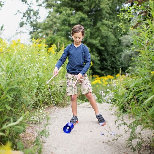 jongen-buitenspeelgoed-diabolo-blauw-het-speellab.jpg Diabolo truc uitvoeren met blauwe diabolo