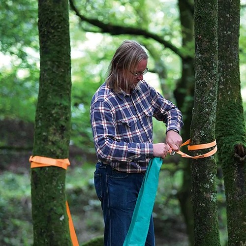 Hape zakschommel bevestigd tussen twee bomen voor avontuurlijk buitenspelen