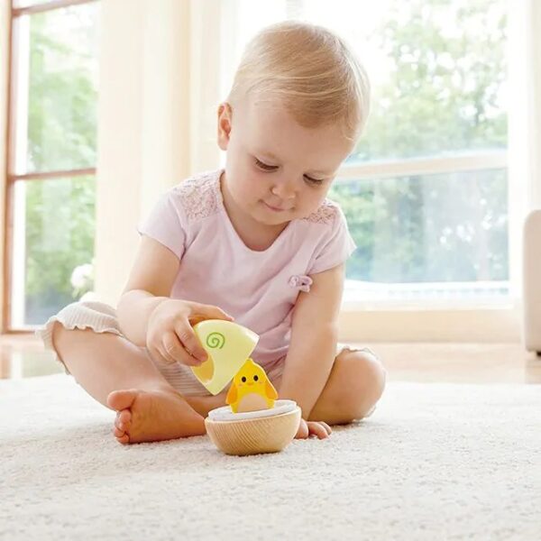 Peuter speelt op grond met Hape wobble tuimelaar Het Speellab